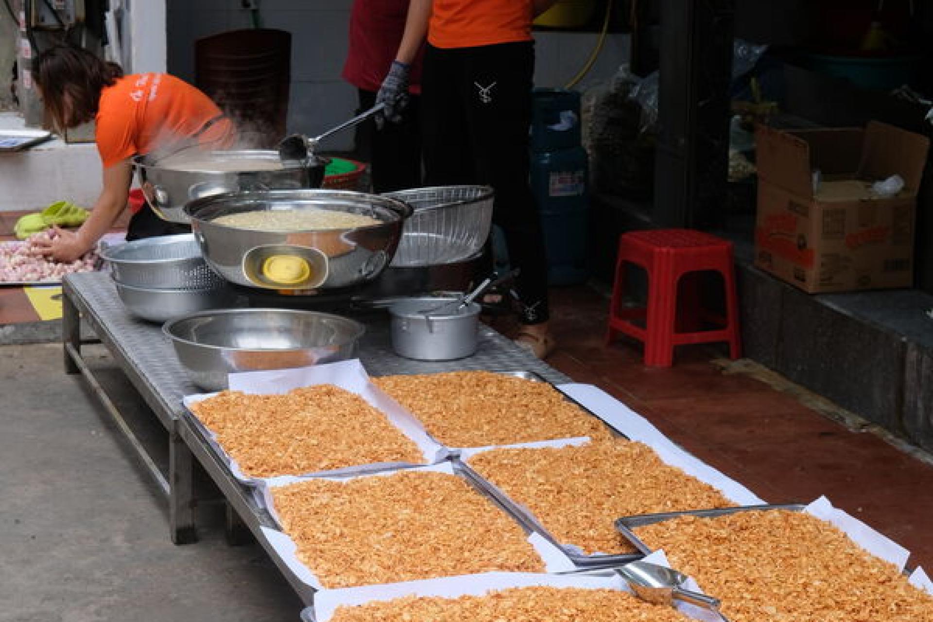 Ba người thợ bóc hành tươi bên hè phố Đất Cảng